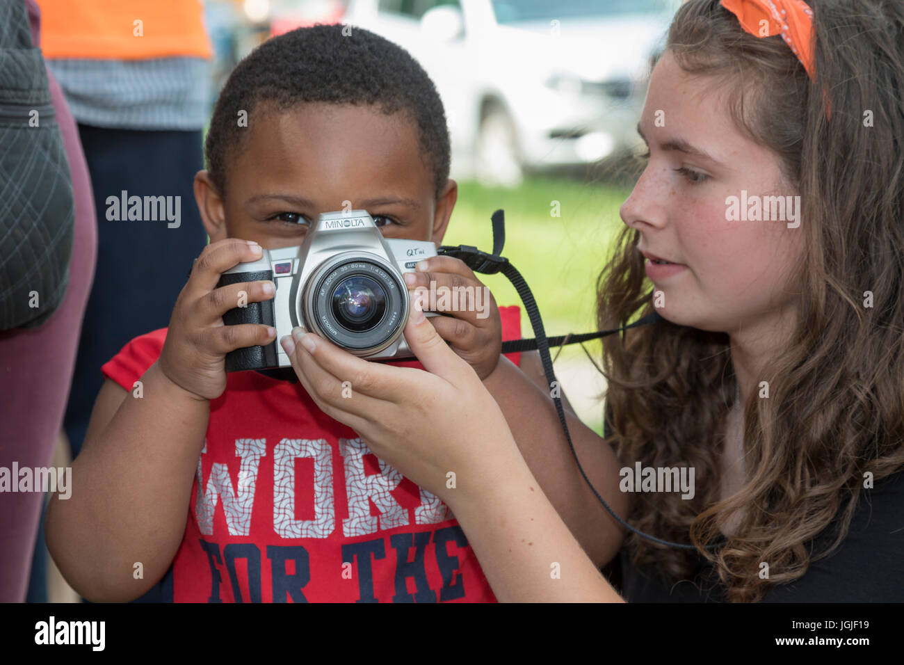 Detroit, Michigan - una ragazza aiuta un giovane ragazzo impara a utilizzare una videocamera. Foto Stock
