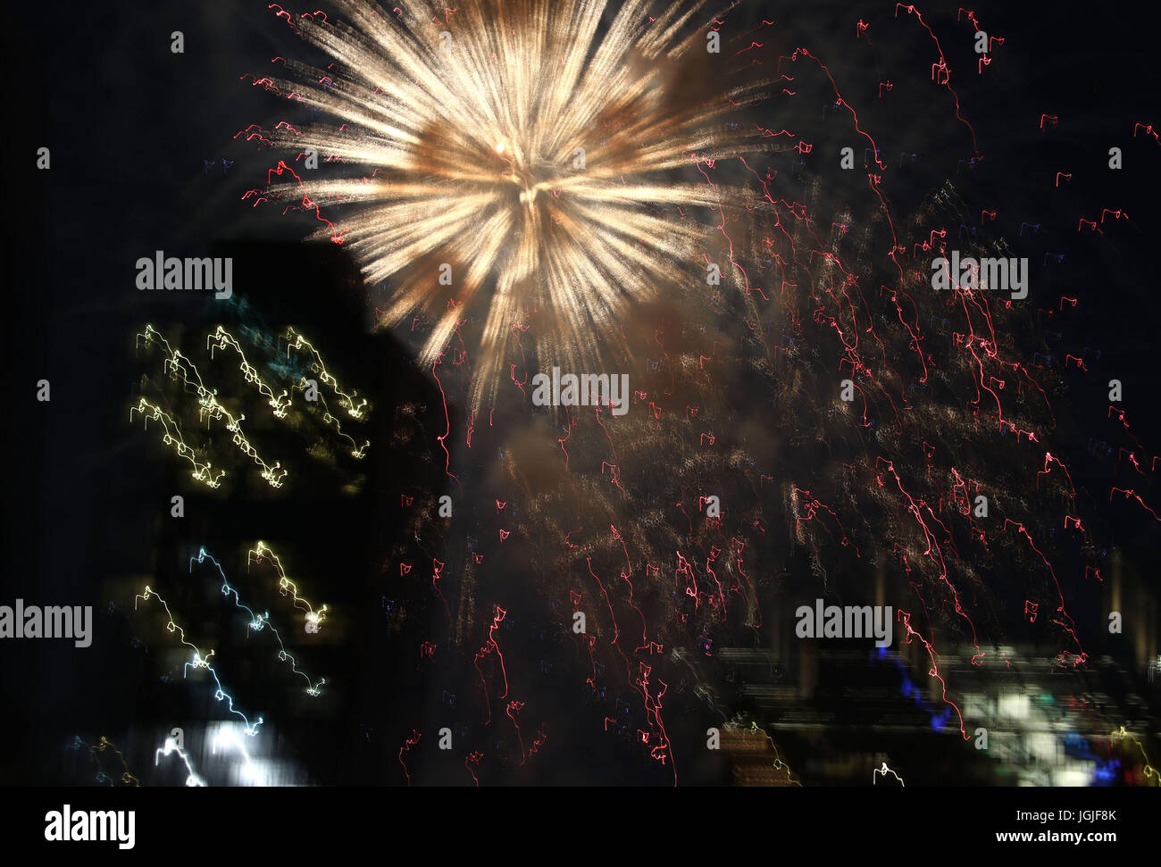 Striature e raffiche di coloratissimi botti da fuochi d'artificio oltre lo skyline di New York Foto Stock
