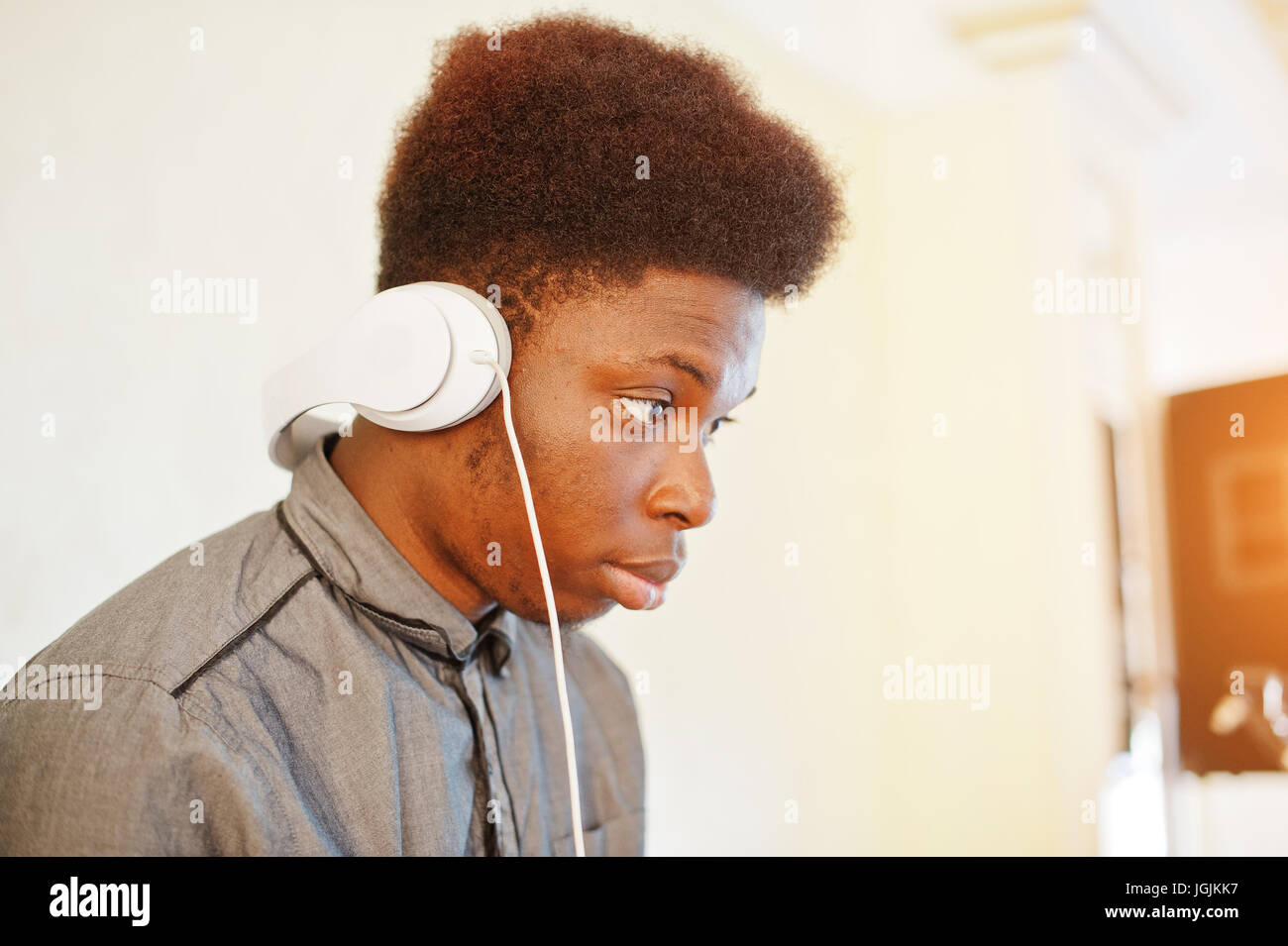 African American dj in enormi cuffie bianche creazione di musica su  pannello di miscelazione Foto stock - Alamy
