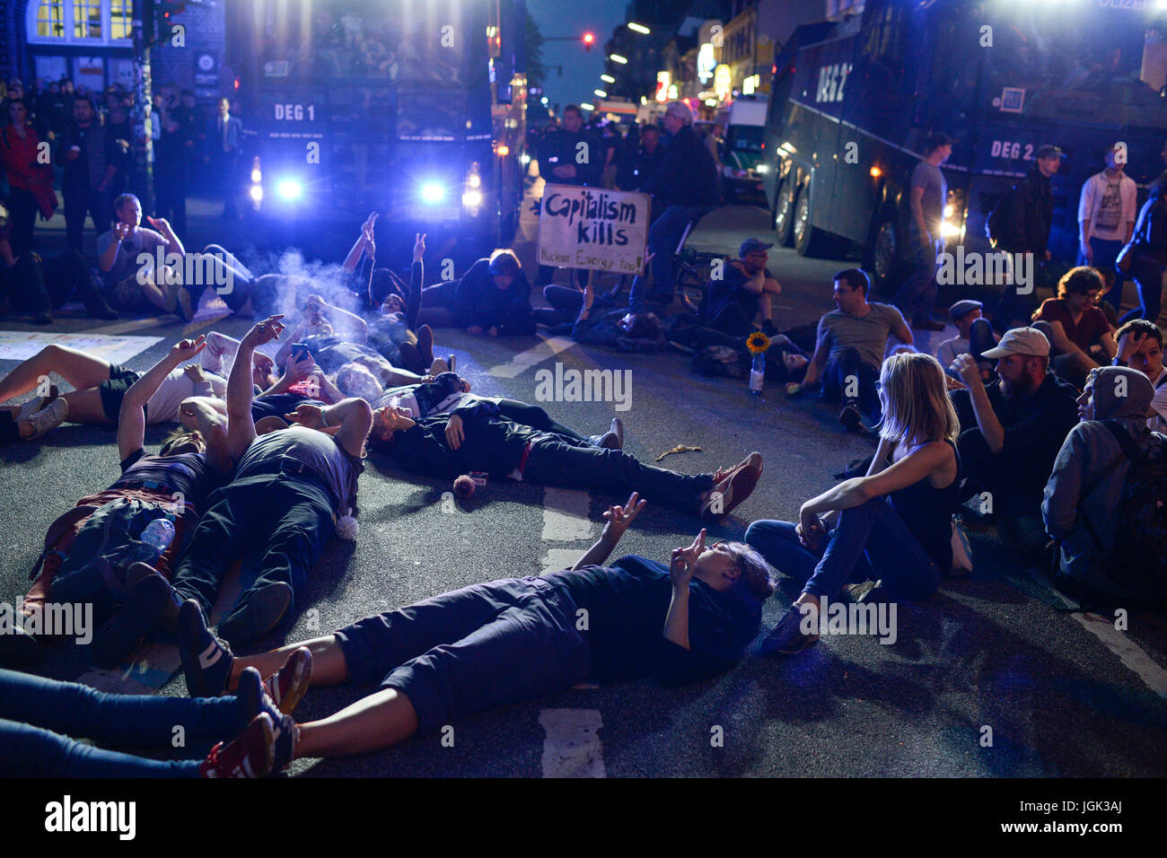 Amburgo, Germania. 07 Luglio, 2017. Germania, Amburgo, protesta rally sul Reeperbahn in St. Pauli contro summit G-20 nel luglio 2017, manifestante seduto di fronte a forze di polizia cannone ad acqua/DEUTSCHLAND, Hamburg St. Pauli, dimostrazione di protesta auf der Reeperbahn gegen G20 Gipfel in Amburgo, vor Sitzblockade Wasserwerfern an der Polizeistation Davidwache Credito: Joerg Boethling/Alamy Live News Foto Stock