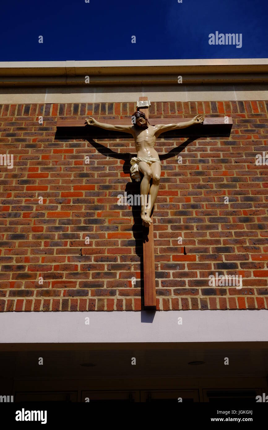Croce sulla parete di una chiesa a Harrow Foto Stock