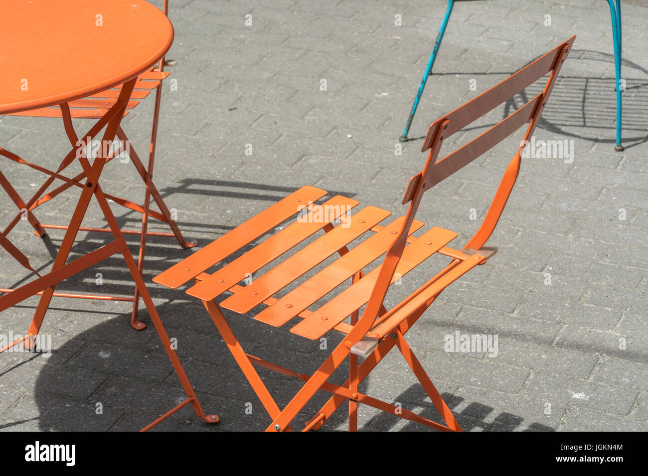 Tavolo arancione e sedia in un caffè sul marciapiede. Per il divaricamento sociale di Covid, caffè esterno, mangiare fuori le regole di Covid, posti vuoti durante Covid nel Regno Unito. Foto Stock