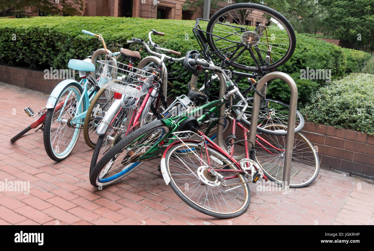 Famiglie disorganizzate confuso ammucchiati capovolto bikes concatenati per portabicicletta Foto Stock