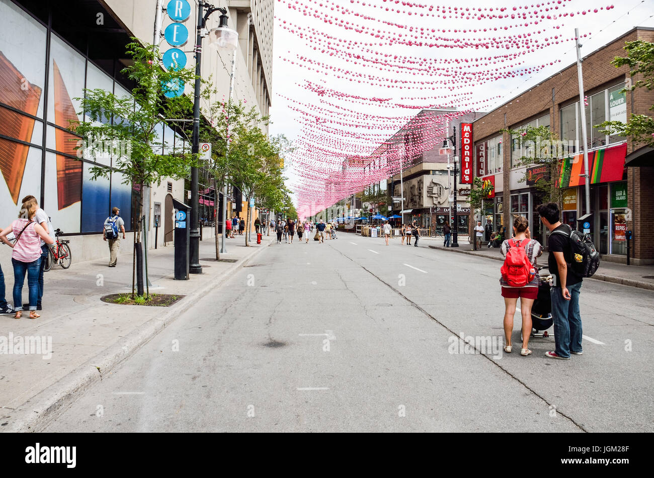 Montreal, Canada - 26 Luglio 2014: la gente camminare su Sainte Catherine Street in Montreal del Gay Village nella regione di Québec con decorazioni pensili Foto Stock