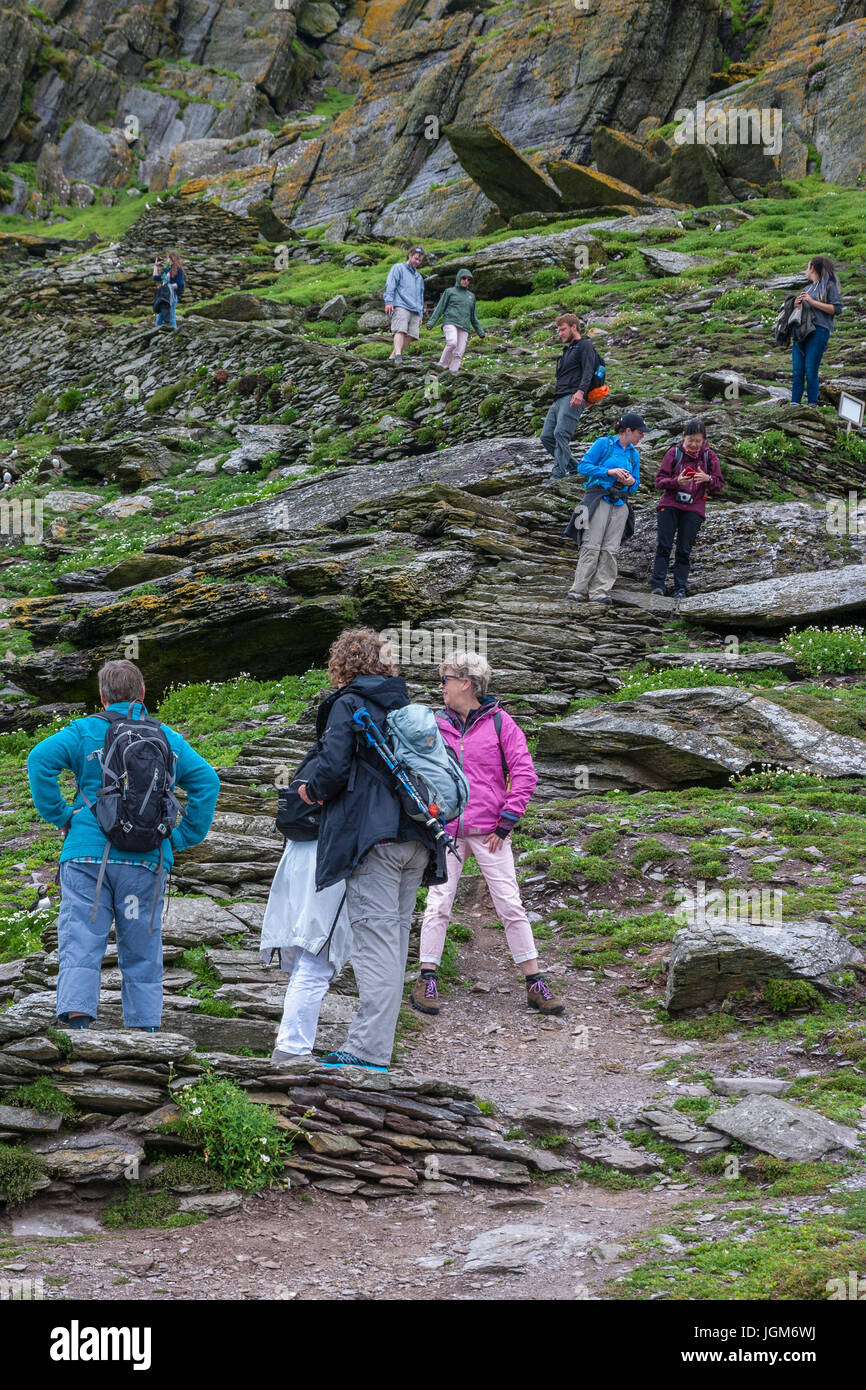 I turisti la scalata di gradini di pietra su Skellig Michael, nella contea di Kerry Irlanda Foto Stock