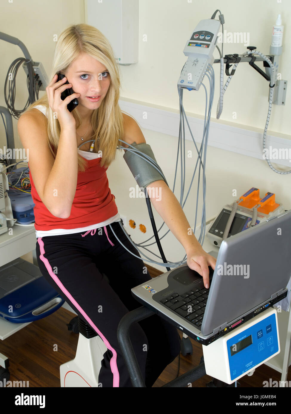 Giovane donna svolge un ergometro test nella pratica medica - una giovane donna su un ergometro in chirurgia, Junge Frau führt einen Ergometer-Test Foto Stock