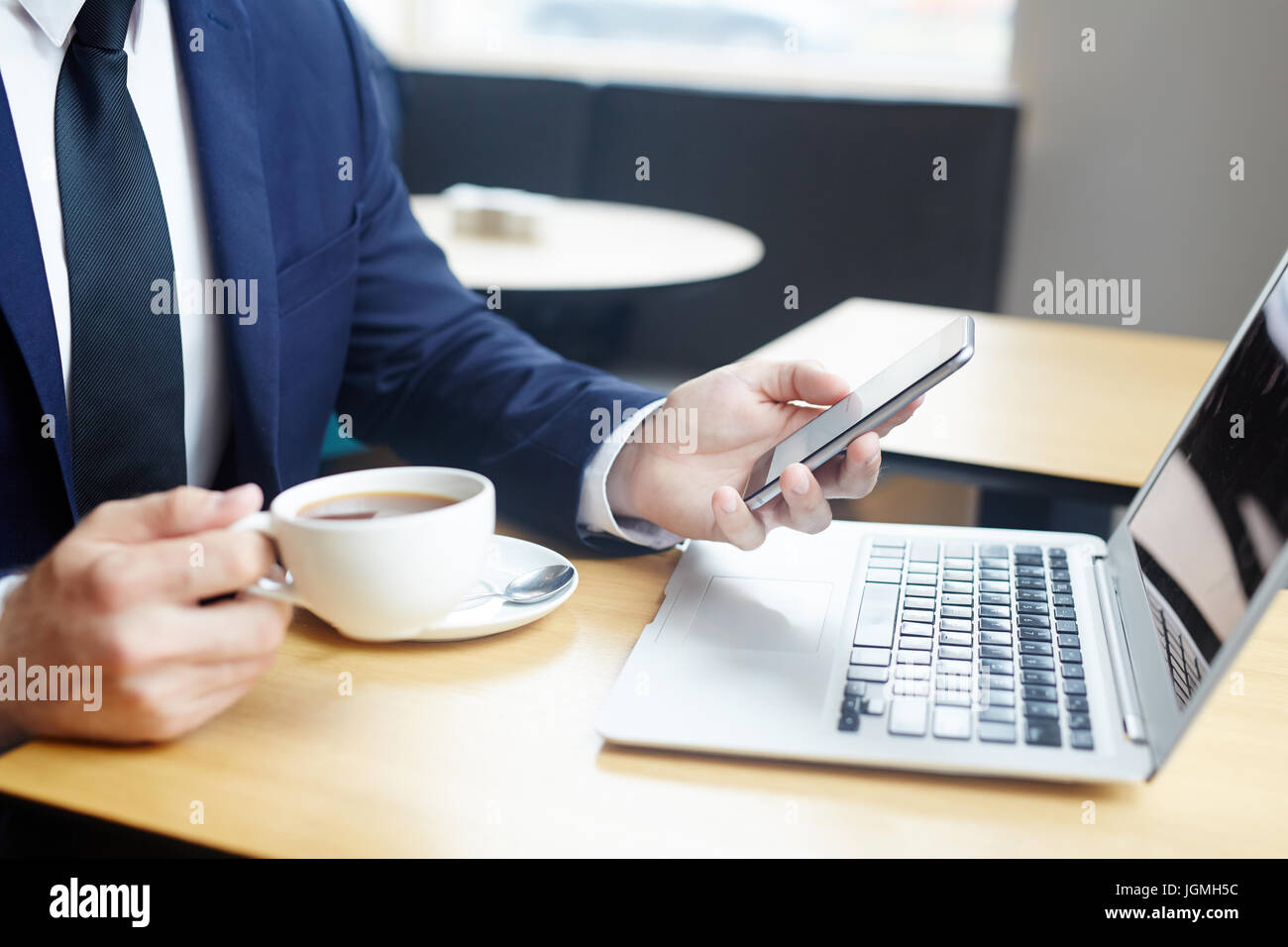 Smartphone in mano di imprenditore elegante avente il caffè Foto Stock