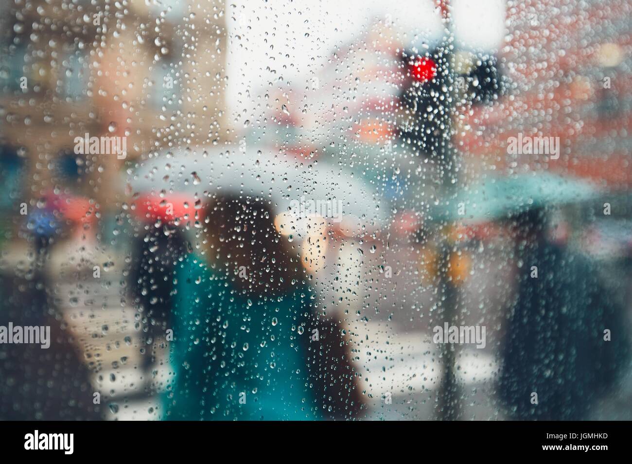Giornata uggiosa in città. Persone in heavy rain. Messa a fuoco selettiva sulle gocce di pioggia. Praga, Repubblica Ceca. Foto Stock