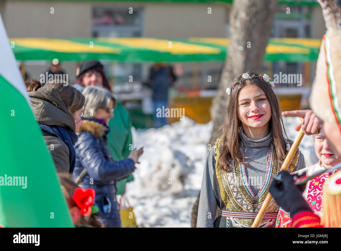 PERNIK, Bulgaria - 27 gennaio 2017: la giovane donna è sempre sorridente e guardando la telecamera che indossa una femmina tradizionale costume di folklore a Surva, INTE Foto Stock