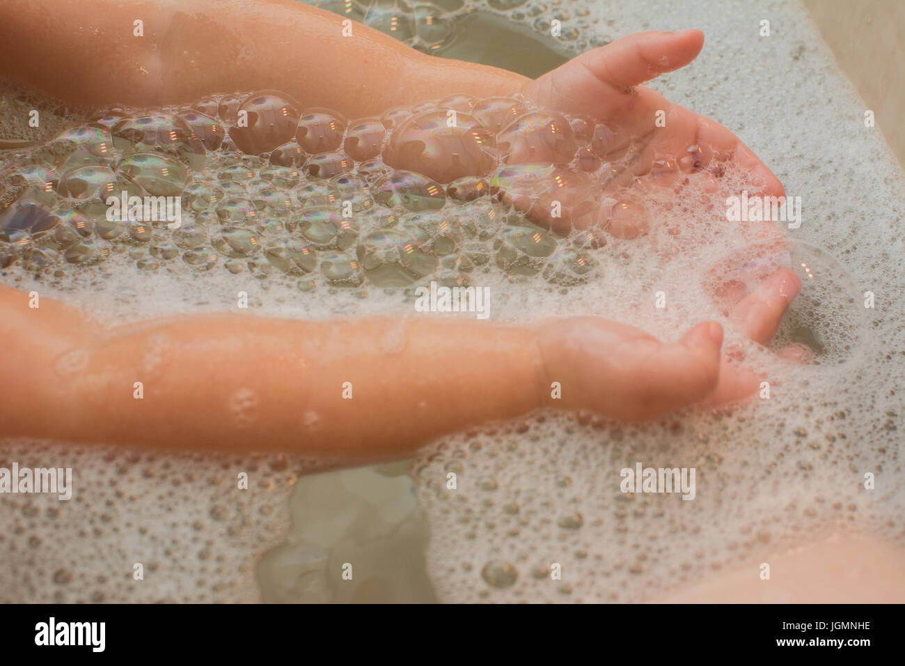Un bambino gioca con bolle in una vasca da bagno. Foto Stock