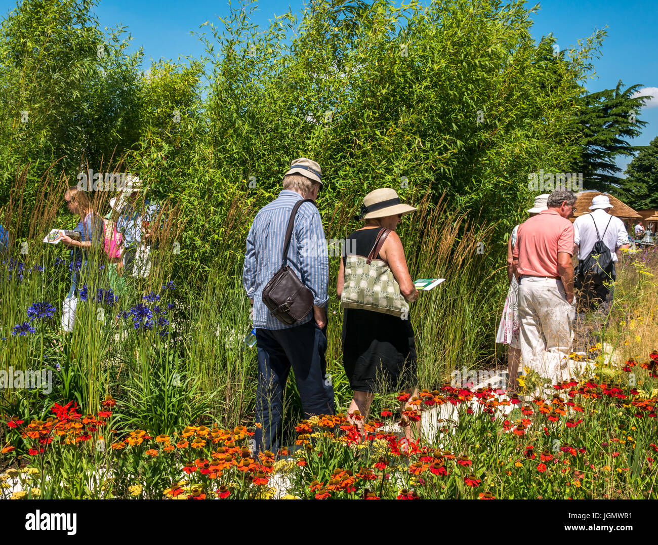 Persone che camminano attraverso il giardino Perennial Sanctuary al RHS Hampton Court Flower Show, Londra, Inghilterra, Regno Unito Foto Stock