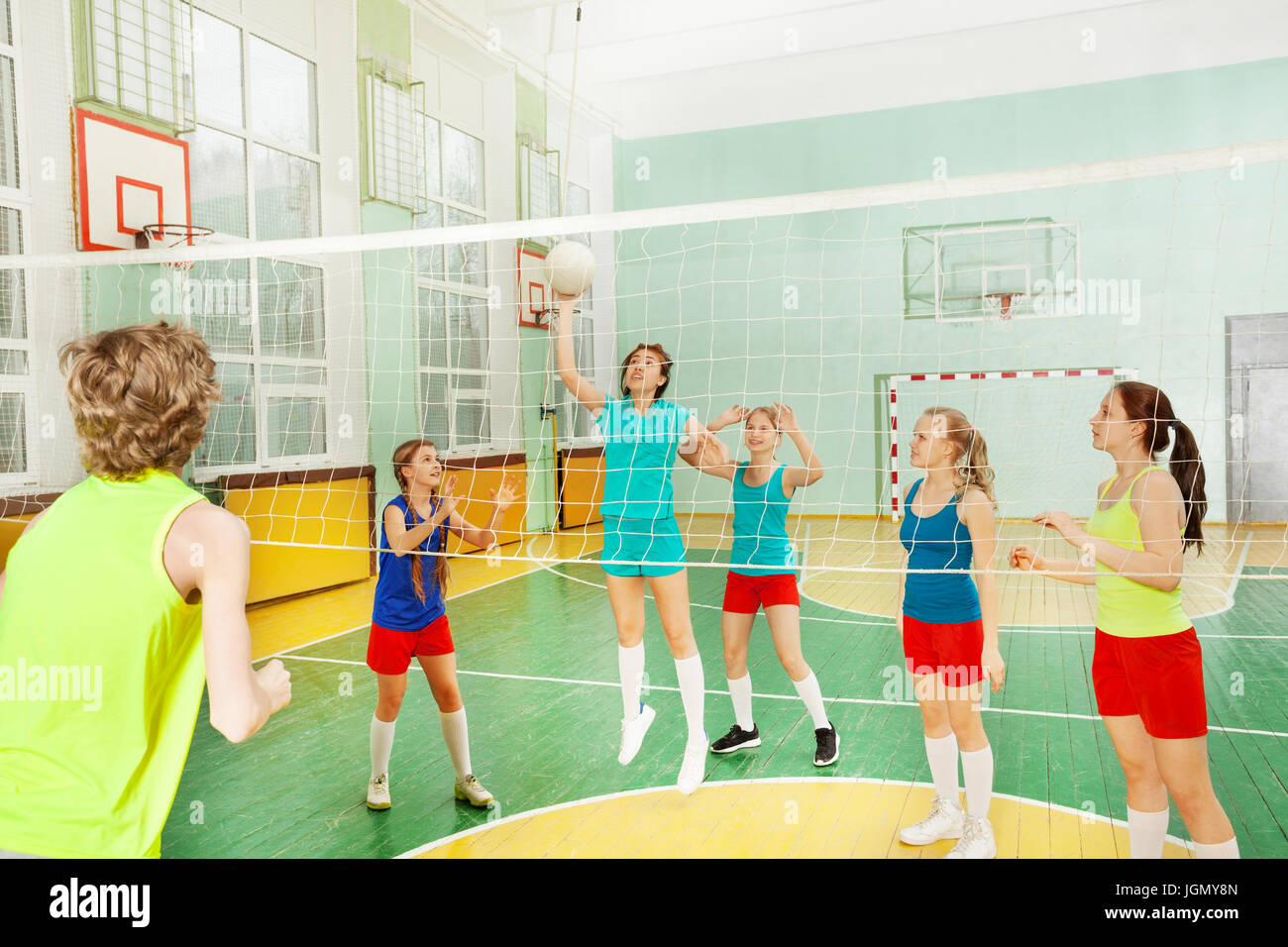 Teen girl serve la palla durante la partita di pallavolo Foto Stock