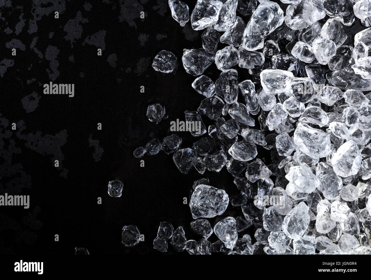 Pezzi di ghiaccio frantumato i cubi su sfondo nero. Copia spazio, vista dall'alto Foto Stock