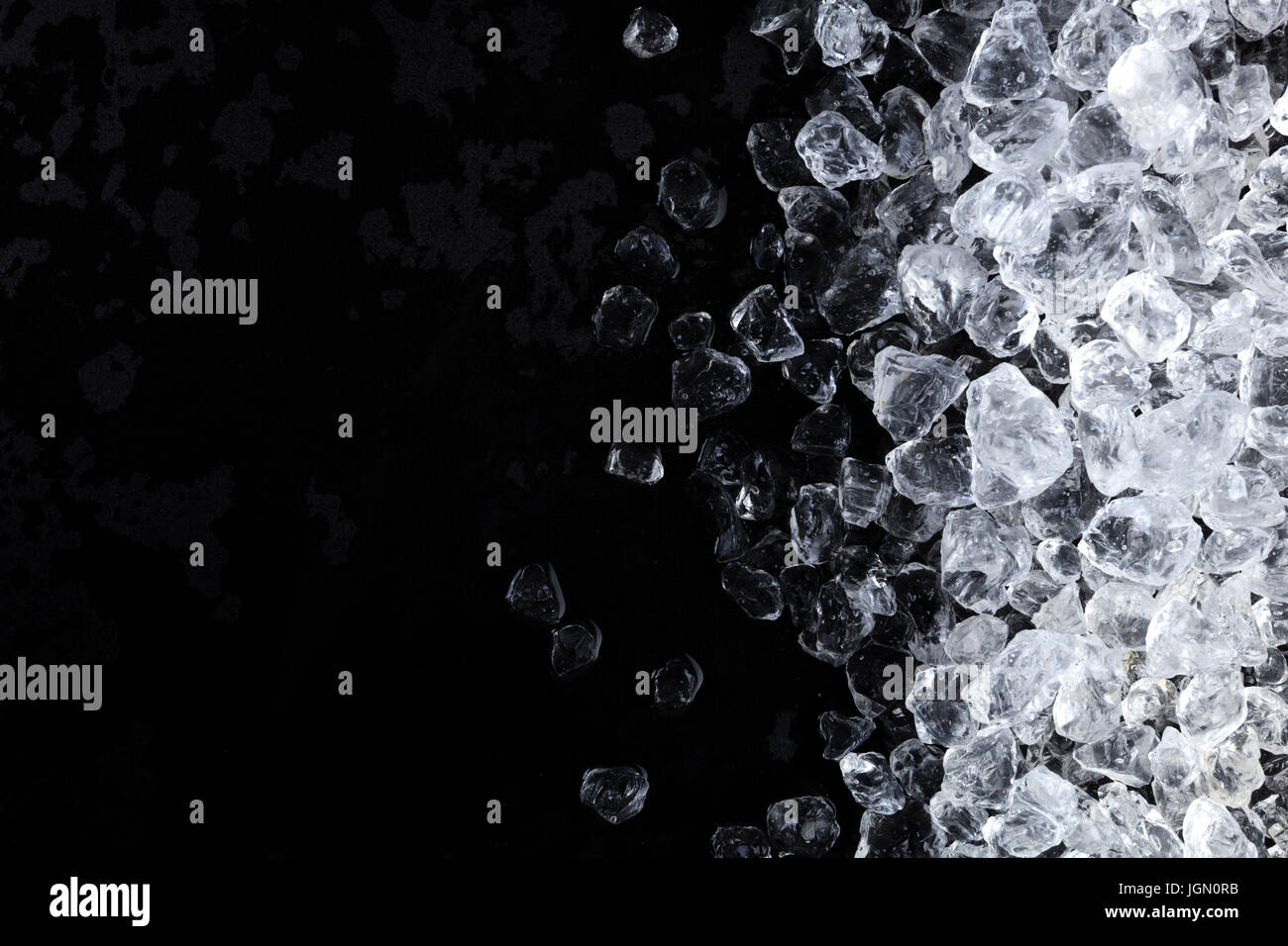 Pezzi di ghiaccio frantumato i cubi su sfondo nero. Copia spazio, vista dall'alto Foto Stock