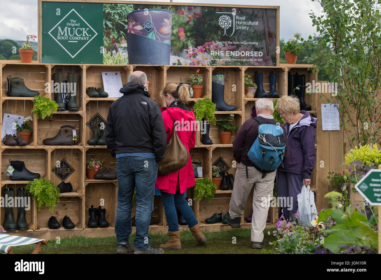 I clienti guardano stivali visualizzati sul Muck Originale Boot azienda commerciale - stallo RHS Chatsworth Flower Show, la Chatsworth House, Derbyshire, Inghilterra, Regno Unito. Foto Stock