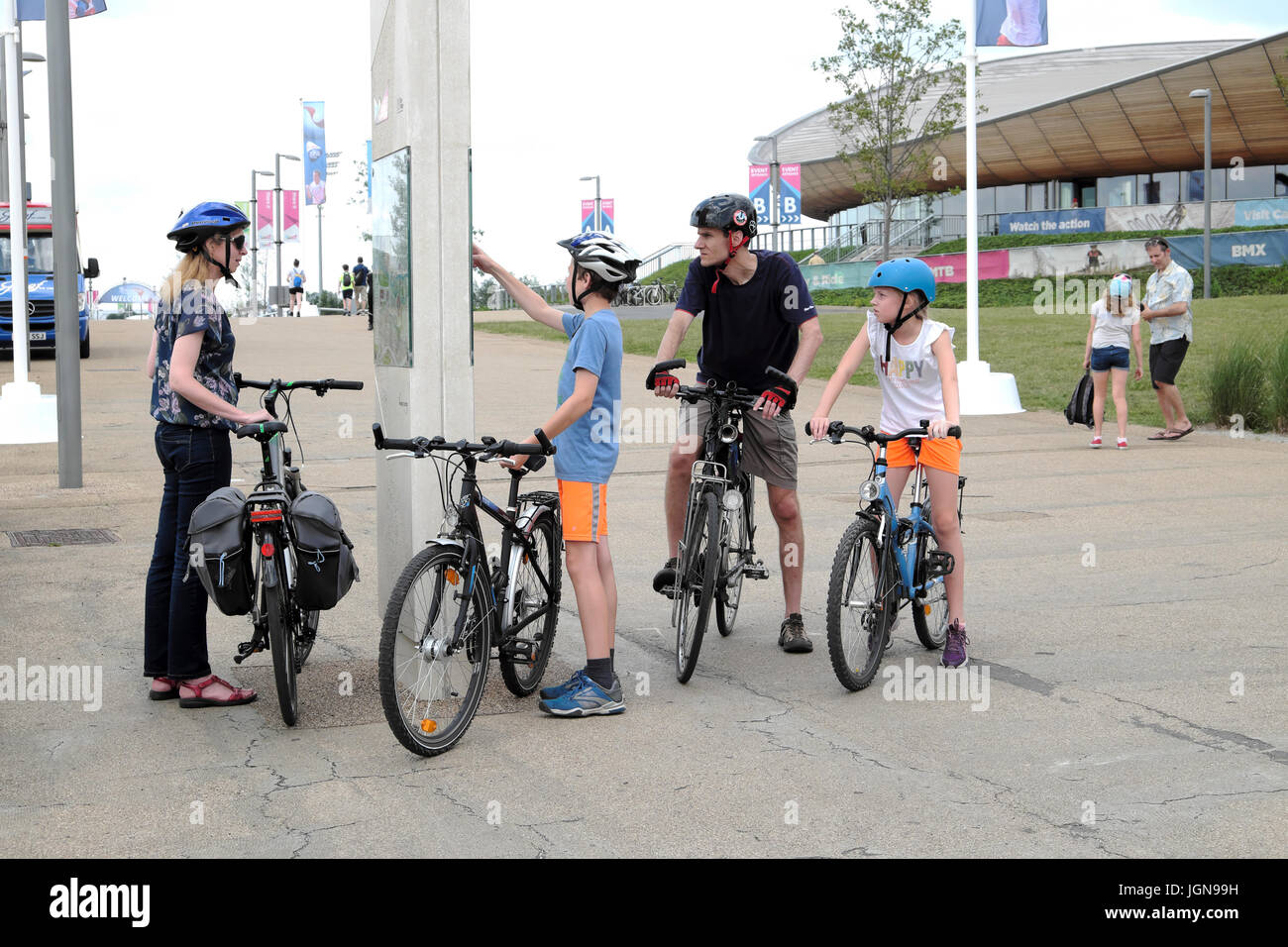 Famiglia con bici guardando al di fuori della mappa la Queen Elizabeth Olympic Park edificio velodromo di Stratford, Newham Est Londra Inghilterra KATHY DEWITT Foto Stock