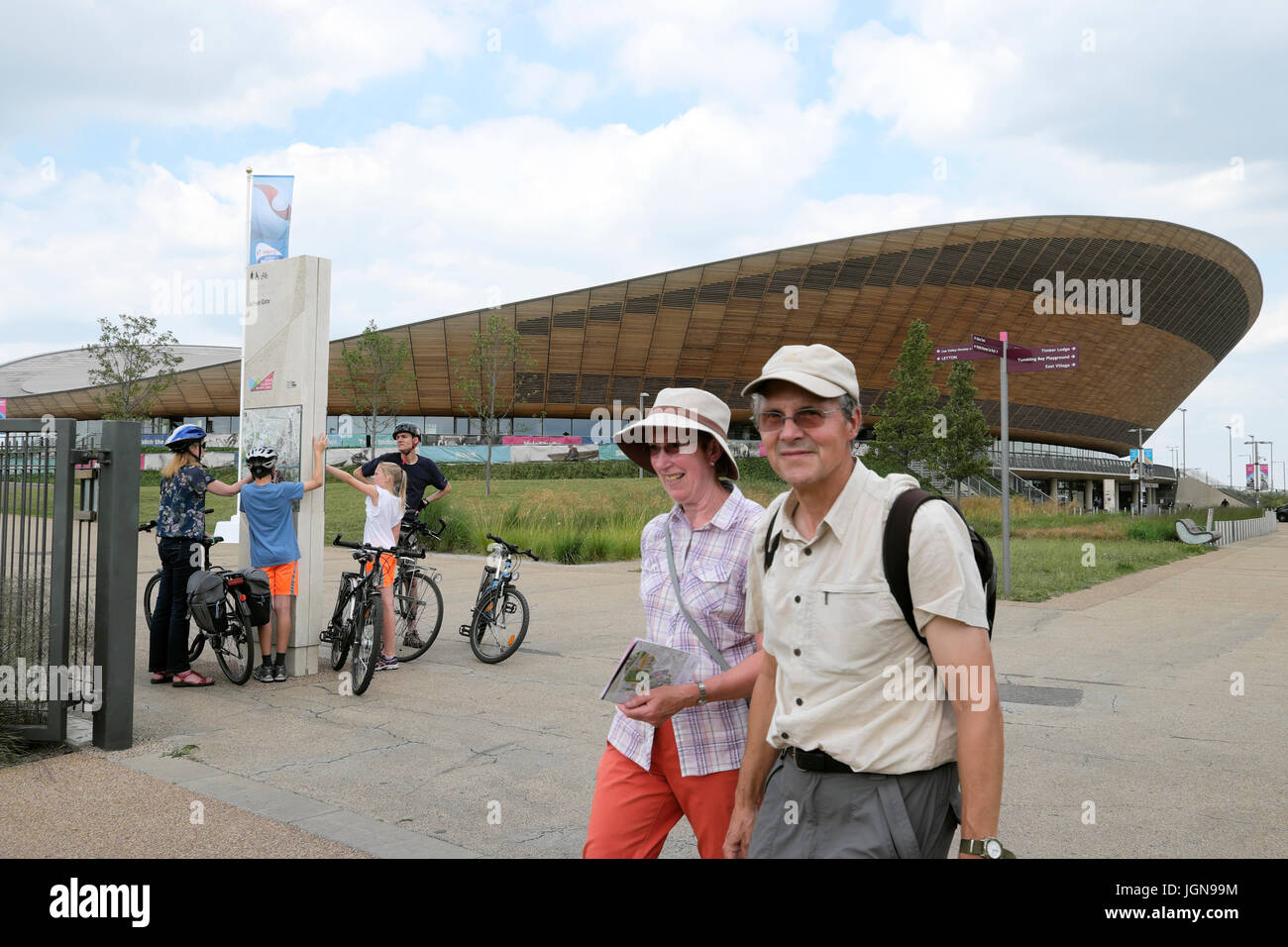 Turisti e famiglie con le biciclette al di fuori della Queen Elizabeth Olympic Park Velodrome ciclismo edificio, Stratford East London Inghilterra England Regno Unito KATHY DEWITT Foto Stock
