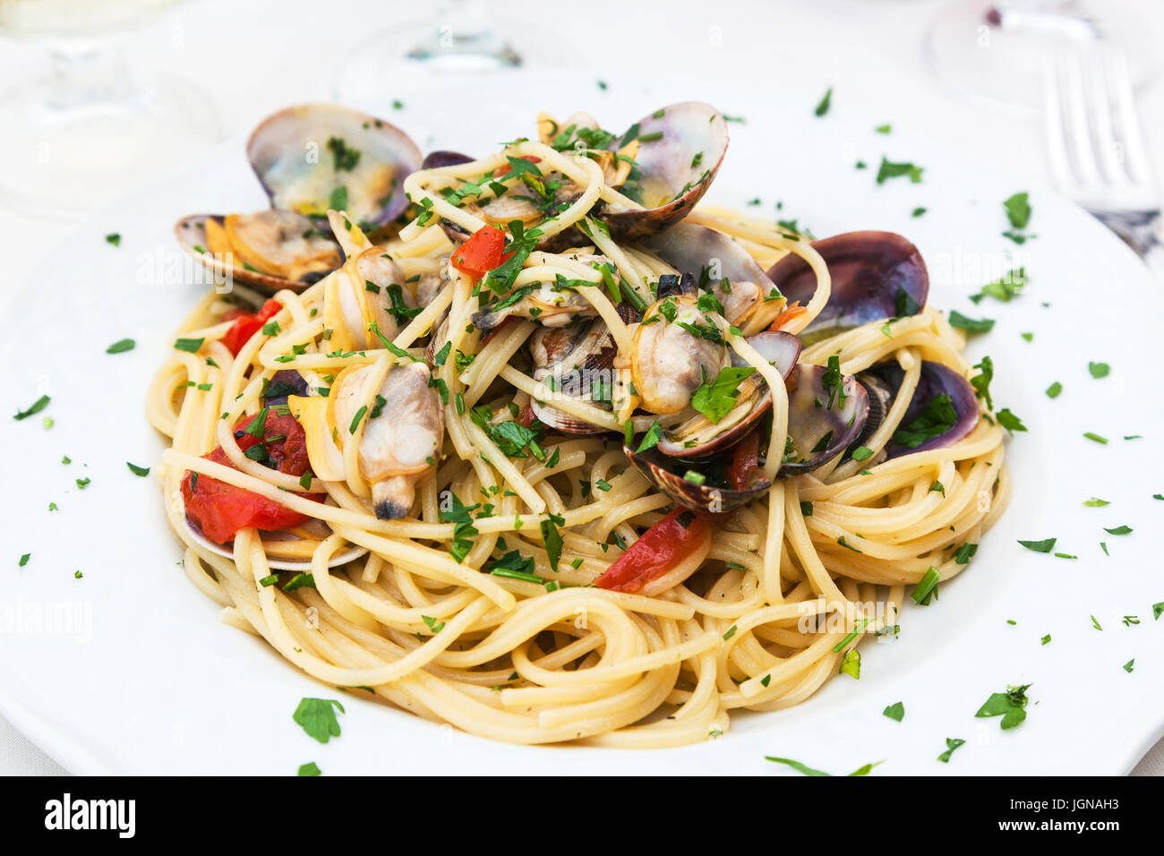 Prodotti tipici italiani - spaghetti alle vongole sulla piastra nel ristorante siciliano Foto Stock
