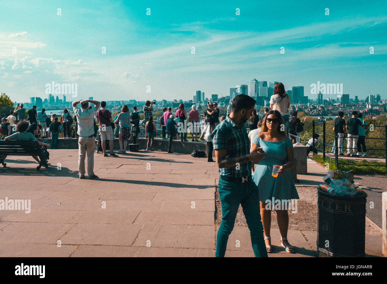 Le persone che si godono la vista a Canary Wharf da Greenwich Park. Foto Stock