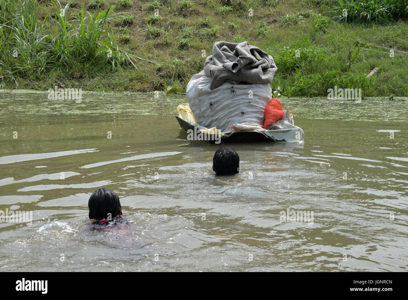 Sirajganj, Bangladesh. 9 lug 2017. Due persone che nuotano per prendere i loro averi a una maggiore massa attraverso una zattera sulle alluvioni in Sirajganj, Bangladesh, in data 8 luglio 2017. Le inondazioni hanno scatenato da pesanti piogge stagionali e onrush di acqua dalle colline attraverso le frontiere indiane hanno parti interessate del Bangladesh e ha lasciato centinaia di migliaia di senzatetto. Credito: Xinhua/Alamy Live News Foto Stock