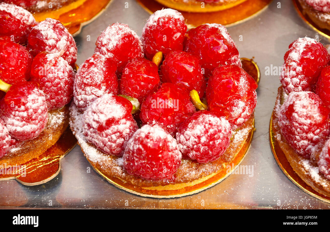 Mini lampone crostate di frutta sul vassoio da forno, visto ad una fiera di strada per celebrare il Giorno della Bastiglia in NYC Foto Stock