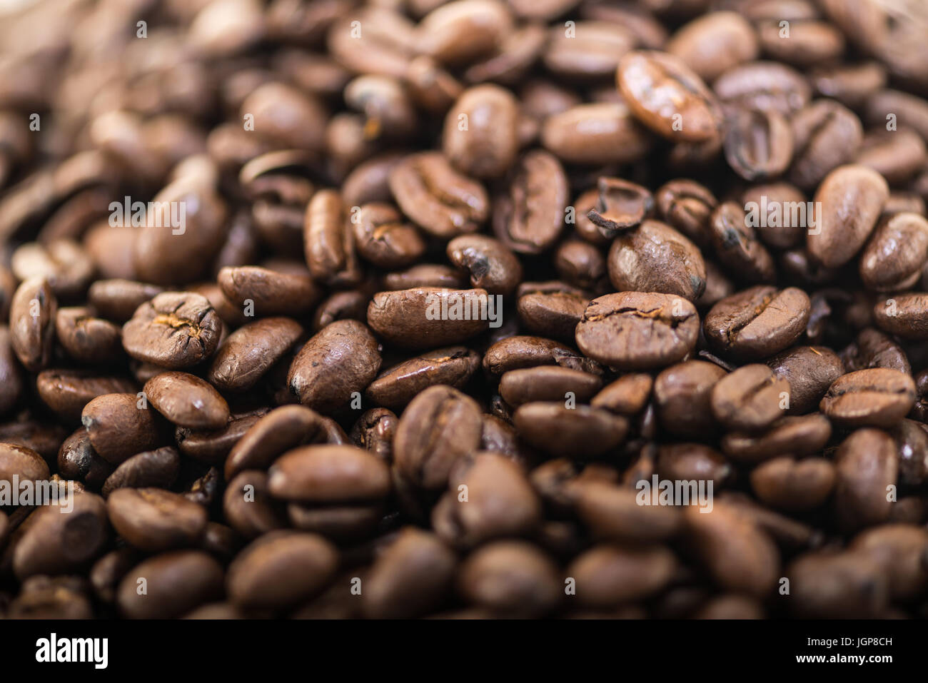 I chicchi di caffè vicino e pali su sfondo bianco. Foto Stock