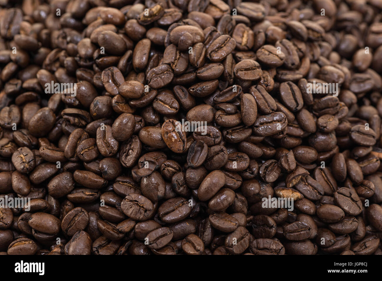 I chicchi di caffè vicino e pali su sfondo bianco. Foto Stock