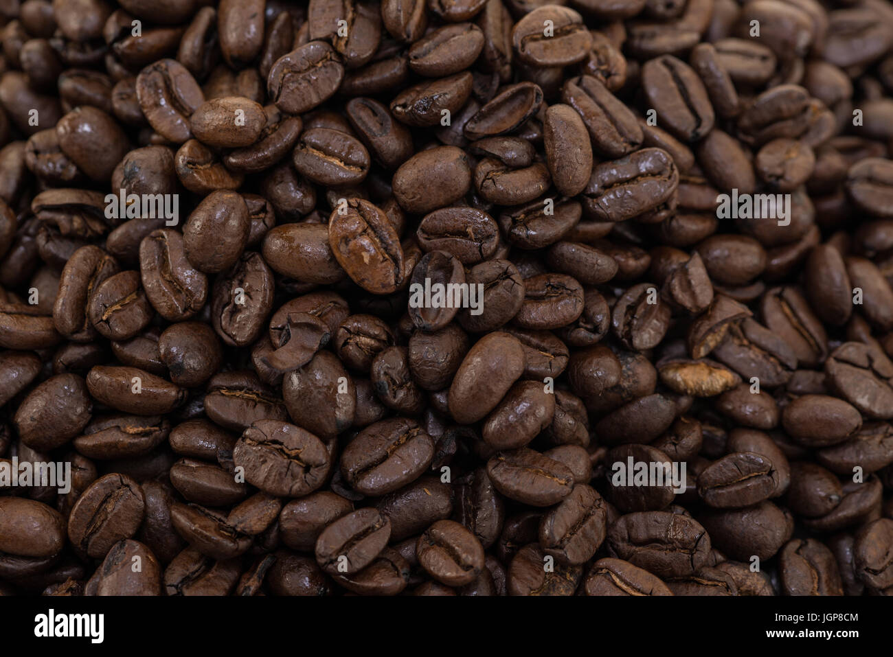 I chicchi di caffè vicino e pali su sfondo bianco. Foto Stock