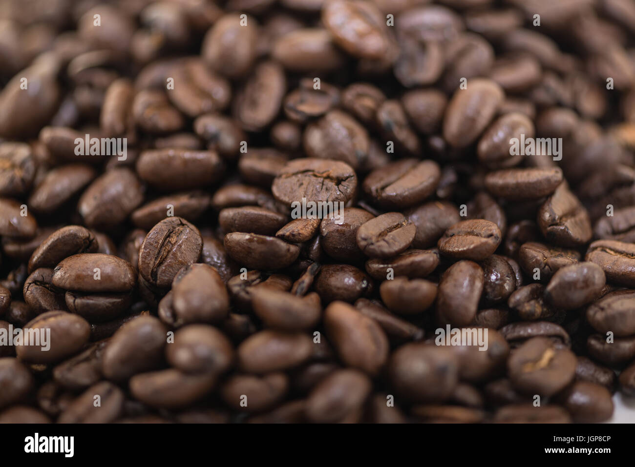 I chicchi di caffè vicino e pali su sfondo bianco. Foto Stock