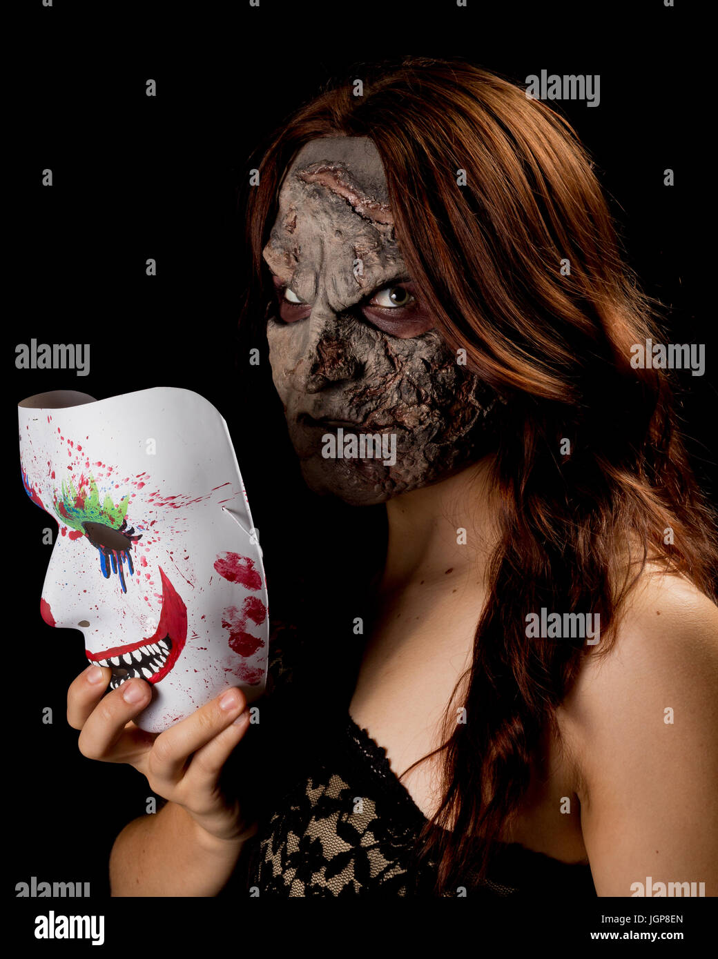 Non si desidera incontrare la ragazza che sta dietro a questa maschera. Femmina modello bruna con un scolpito personalizzato apparecchio contro uno sfondo nero. Halloween/orrore Foto Stock