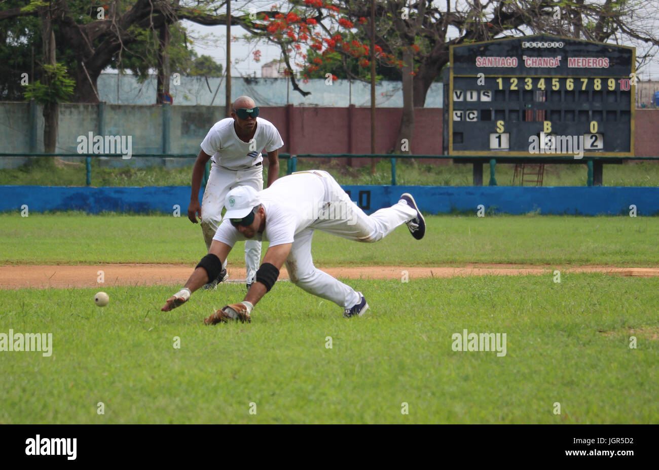Un cieco di giocatore di baseball tenta di prendere la palla durante una sessione di formazione a Santiago "" Changa Mederos stadium di Havana, Cuba, 4 giugno 2017. All'interno della sfera in gomma sono due campane che squillano quando la sfera si sposta. Foto: Guillermo Nova/dpa Foto Stock
