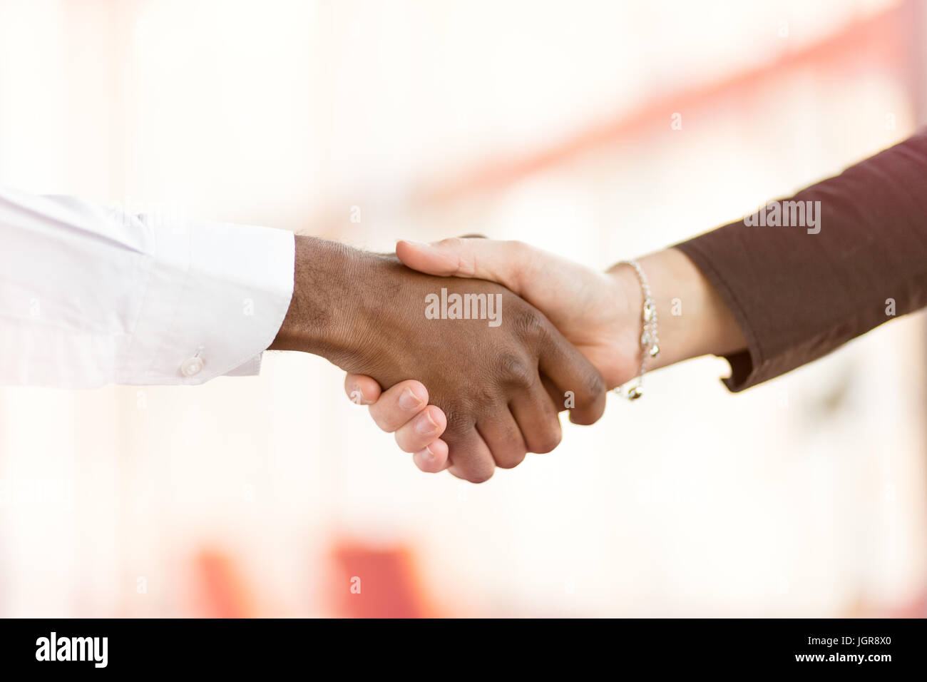 Le persone sul luogo di lavoro: uomo e donna hand shaking in occasione di una riunione Foto Stock