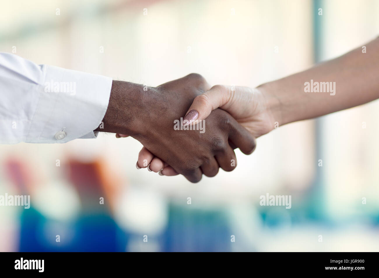 Le persone sul luogo di lavoro: uomo e donna hand shaking in occasione di una riunione Foto Stock