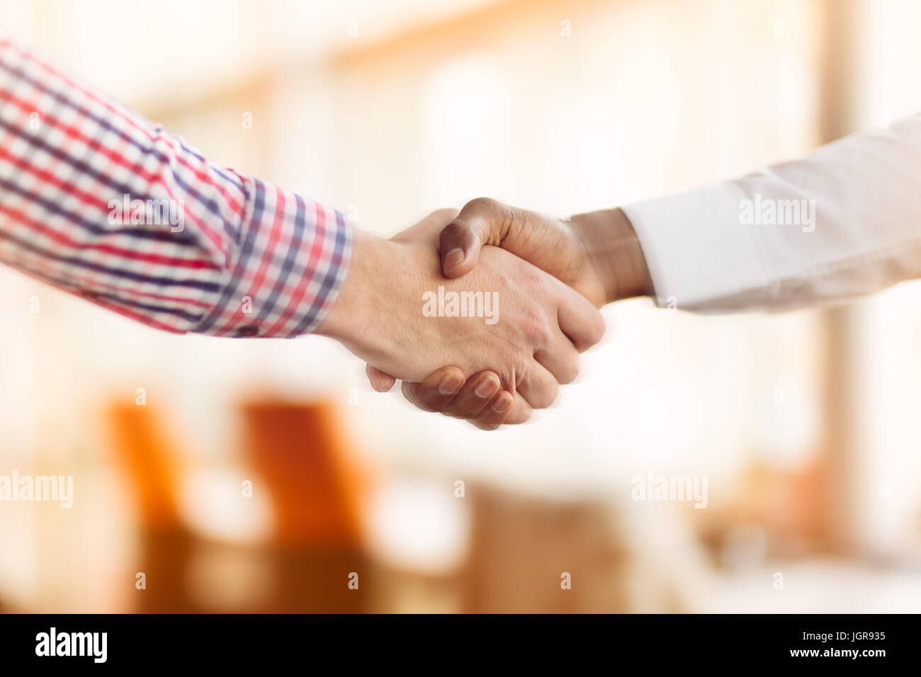 Stretta di mano tra africani e di un uomo caucasico Foto Stock