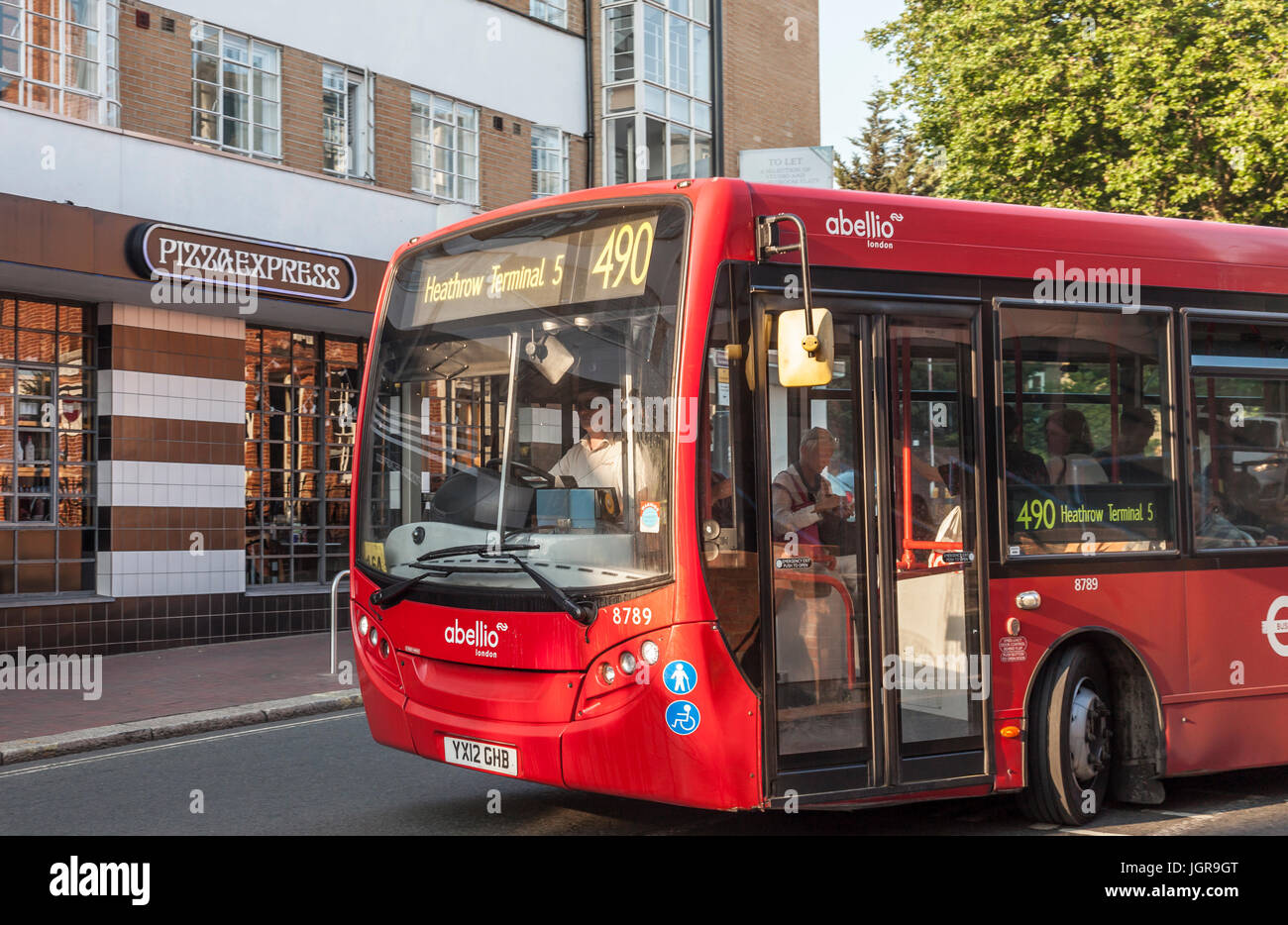 Red single decker London bus n. 490 al Terminal 5 di Heathrow passando il esterni art deco della Pizza Express ristorante a Richmond, Greater London. Foto Stock