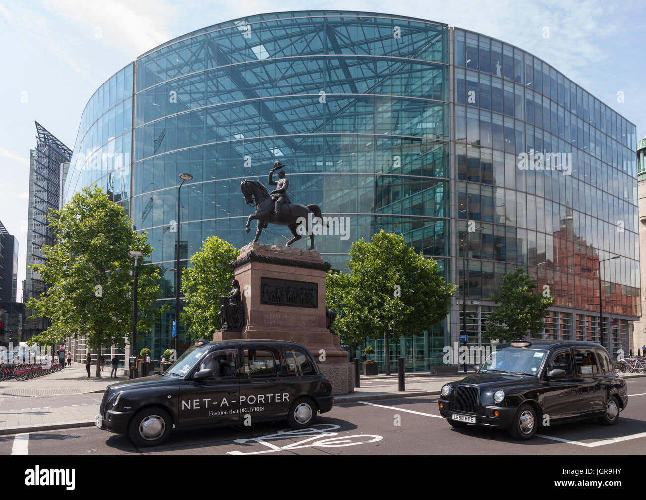 Due Taxi passare il principe Albert statua equestre di Holburn Circus. J. Sainsbury's Headquarters in background. Foto Stock