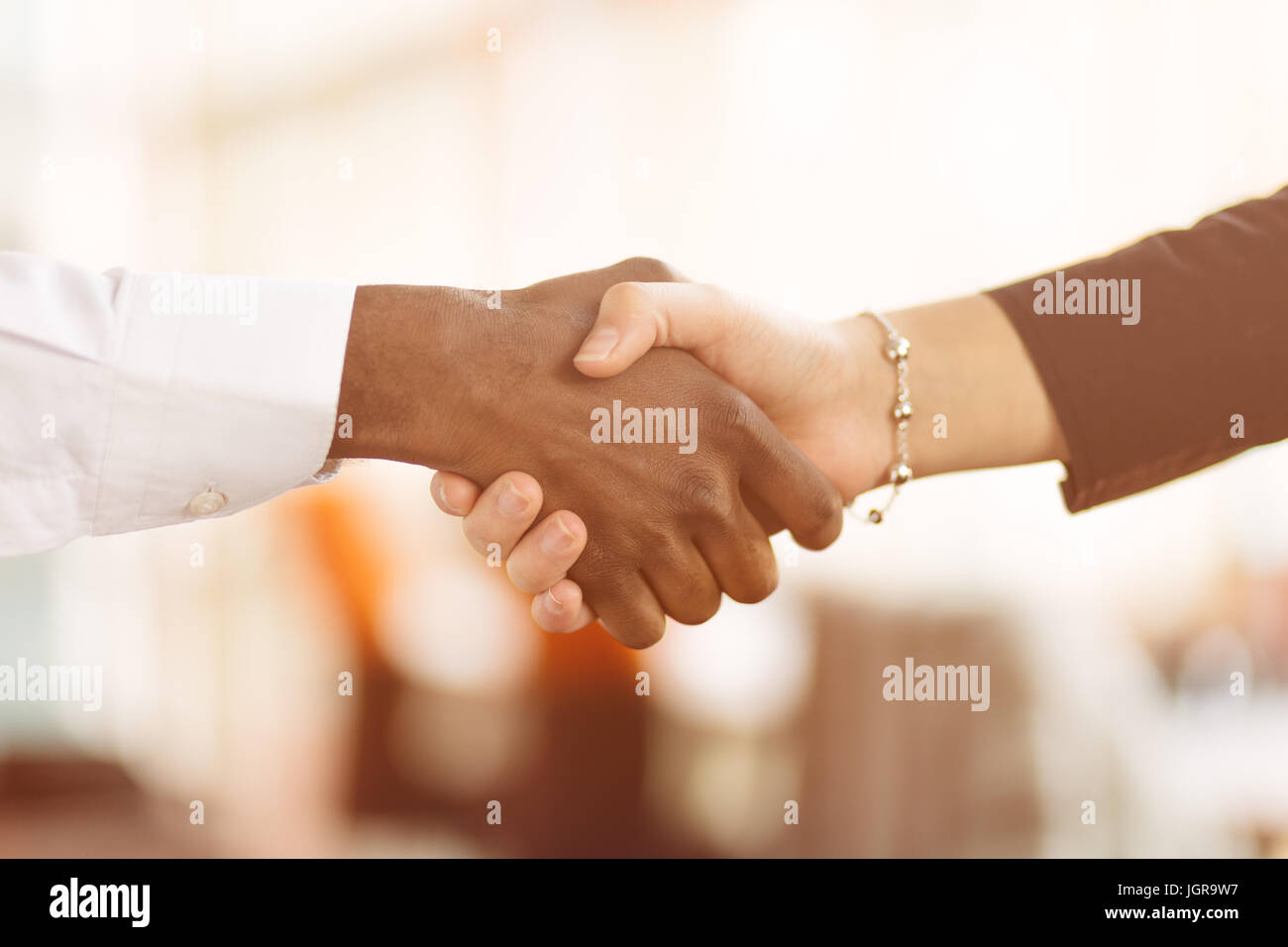 Le persone sul luogo di lavoro: uomo e donna hand shaking in occasione di una riunione Foto Stock