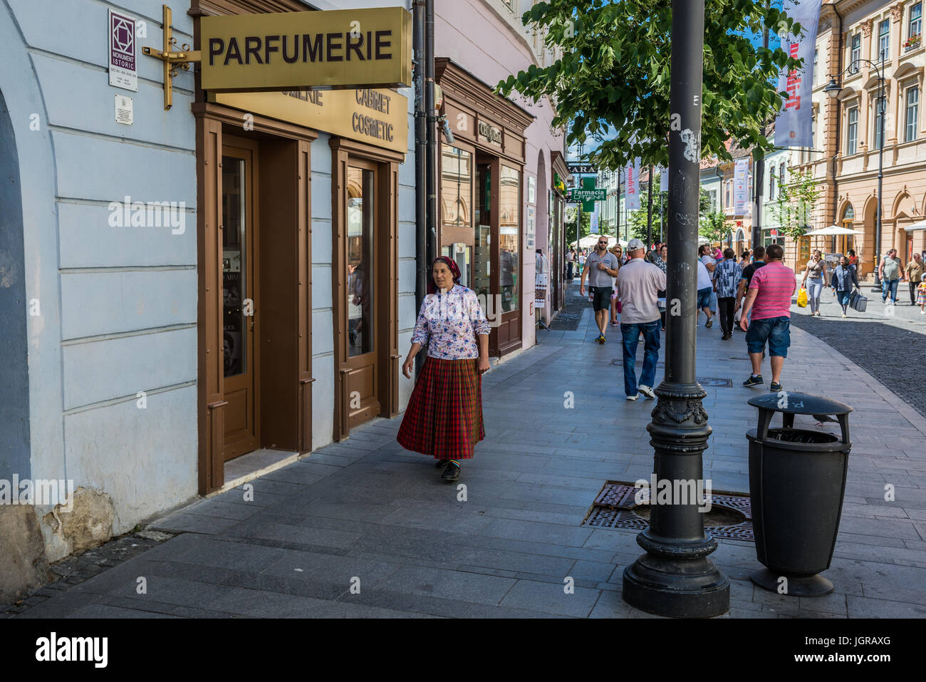 Vecchia donna weraing abito tradizionale su Nicolae Balcescu Street nel centro storico della città di Sibiu della Transilvania regione, Romania Foto Stock