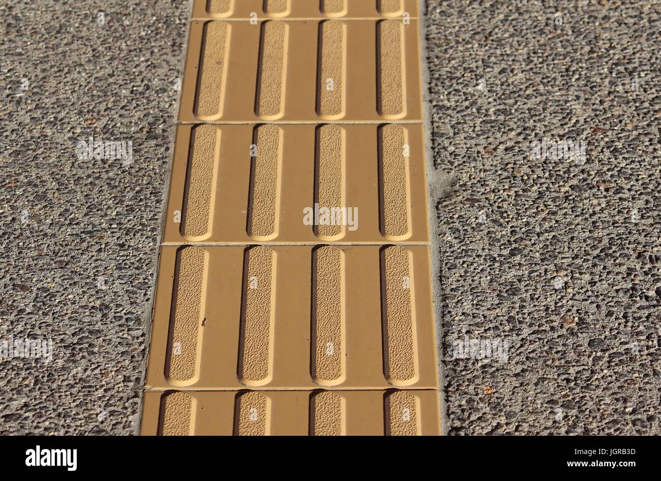 Arancio brillante con pavimentazioni tattili Foto Stock