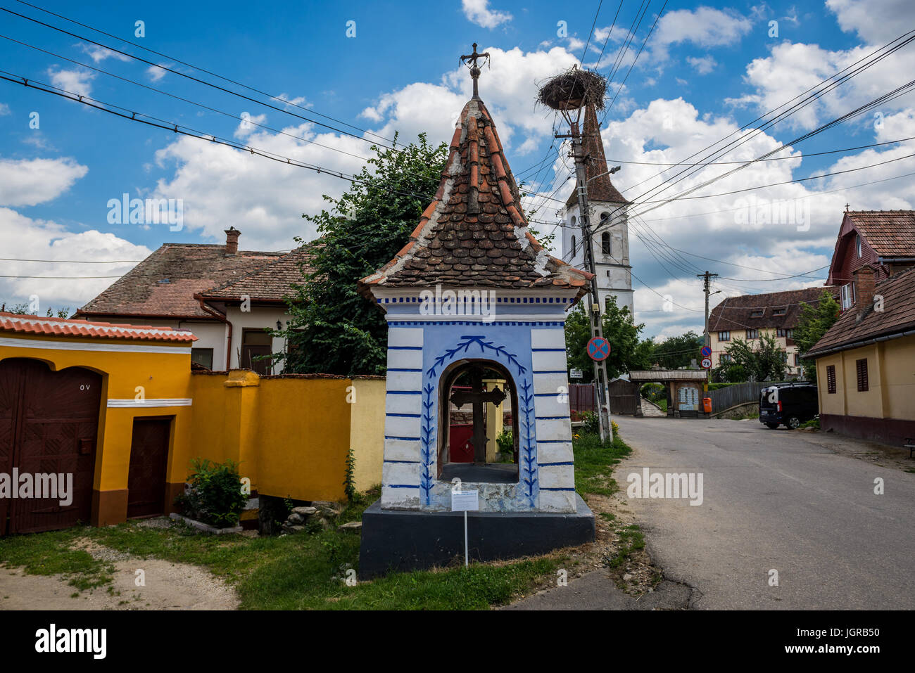 Piccola edicola nel villaggio di Sibiel famoso dalla tradizionale architettura sassone, Transilvania in Romania. Chiesa della Santa Trinità sullo sfondo Foto Stock