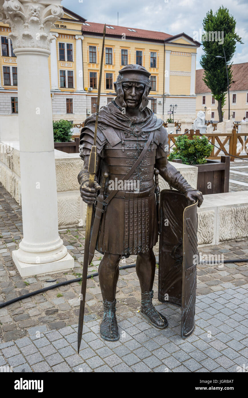 Legionario romano statua in bronzo in accanto alle rovine romane in Alba Carolina fortezza in Alba Iulia città situata nella contea di Alba, Transilvania, Romania Foto Stock