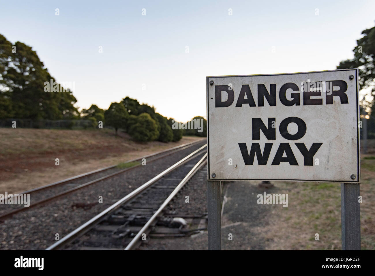 Un segno di avvertimento di pericolo nei pressi di un binario ferroviario Foto Stock