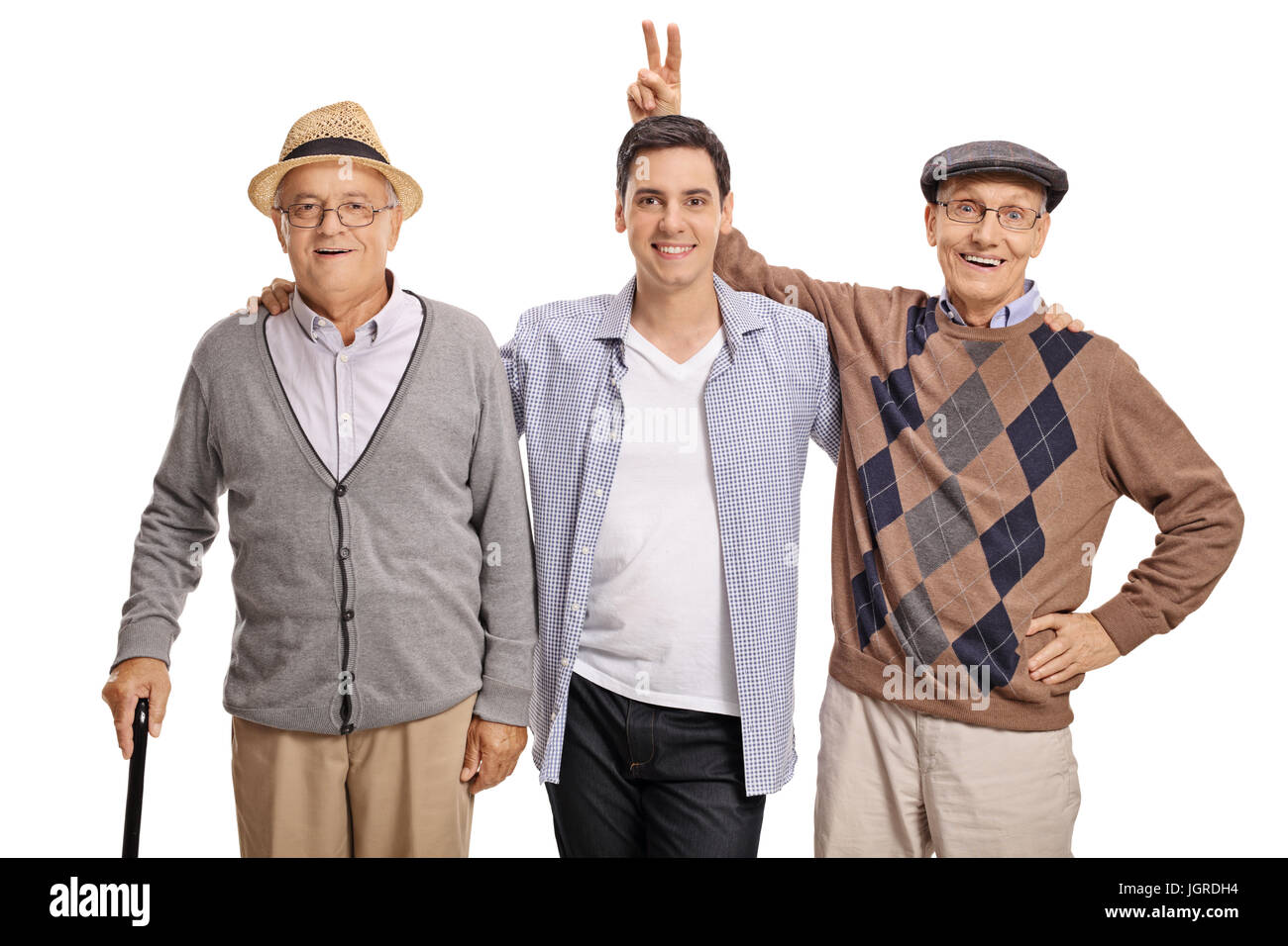Giovane ragazzo con due uomini maturi con uno di loro pranking lui con orecchie di coniglietto isolati su sfondo bianco Foto Stock