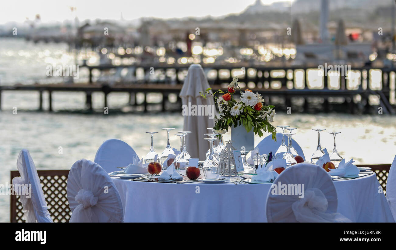 Matrimonio di lusso di ricezione da parte del mare. Tabella di nozze con una bellissima vista sul mare. Ricevimento di nozze luogo pronto per gli ospiti. Foto Stock