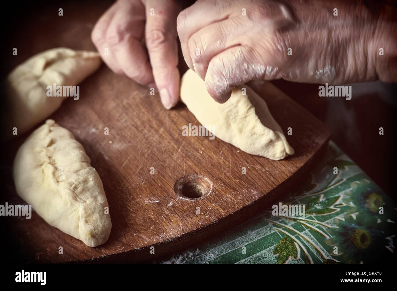 La cottura di torte a casa. Piatti fatti in casa. Mia nonna le mani schiaffeggiato il grafico a torta. Foto Stock