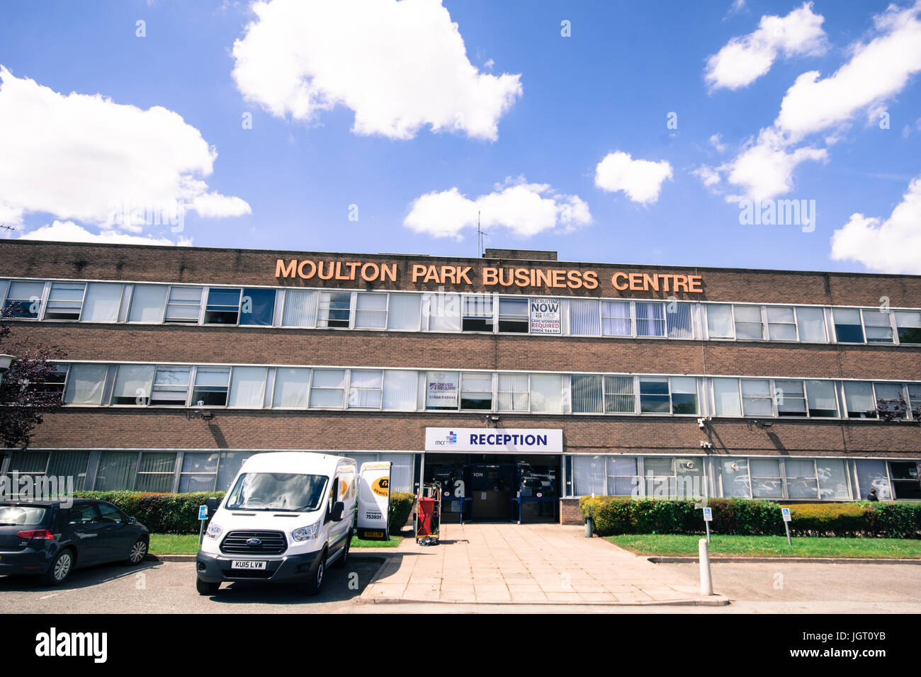 Moulton Business Center o parco ingresso frontale Northampton e cartello reception furgone bianco di fronte e auto bianco soffice nuvole zona pavimentata molte finestre Foto Stock