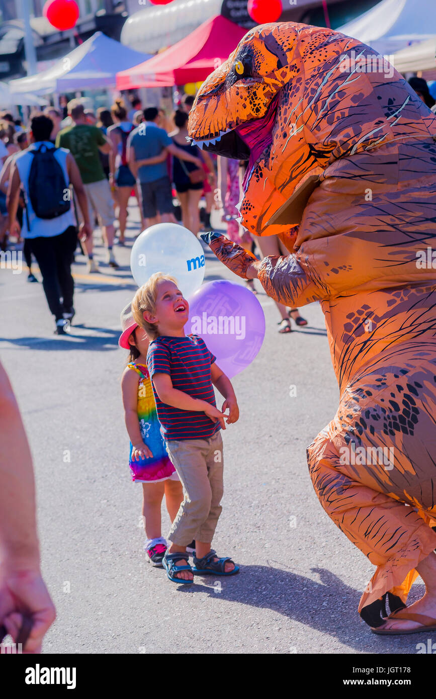 Stomping plastica fuori dell'inquinamento. La consapevolezza di plastica dinosauro al Festival Khatsalano, Kitsilano, Vancouver, British Columbia, Canada. Foto Stock
