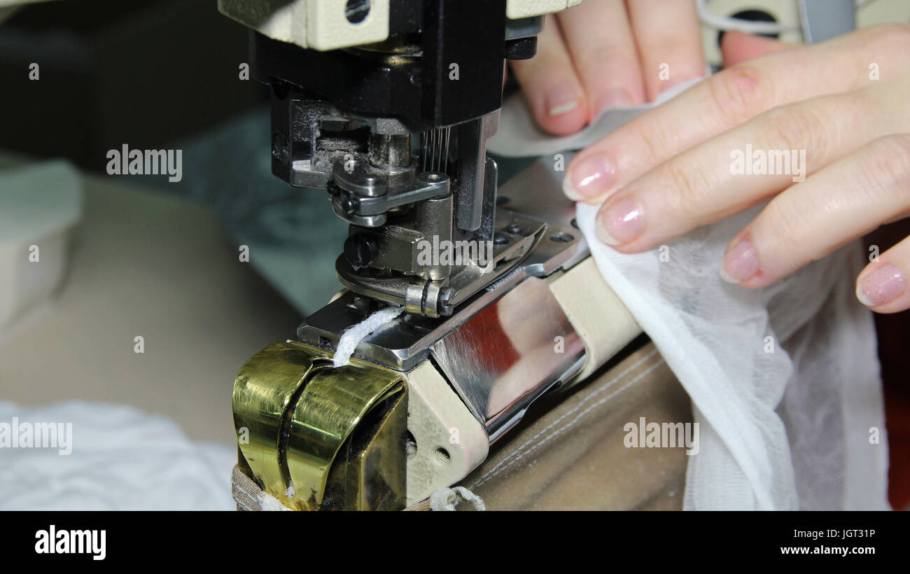 Close up ritratto di mani di sarta cucito con macchina per cucire industriale. Foto Stock