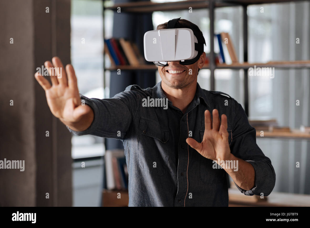 Giovane uomo curioso test gli sviluppi più recenti in fatto di giochi Foto Stock