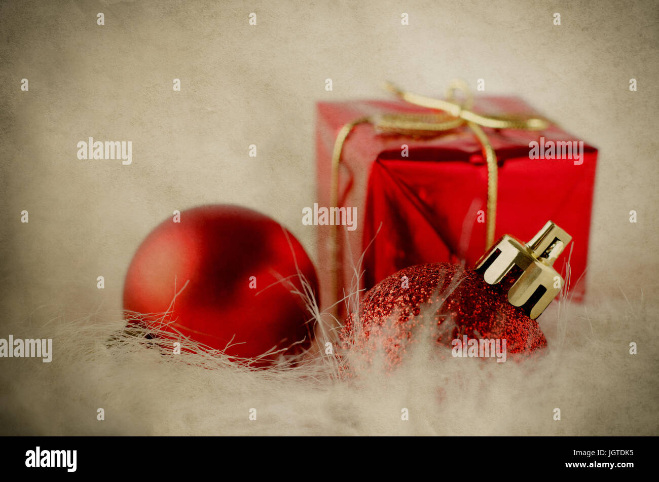 Selezione di rosso e oro Ornamenti natale su bianco finta pelliccia con ingiallito e stagionato pergamena vintage effetto. Foto Stock